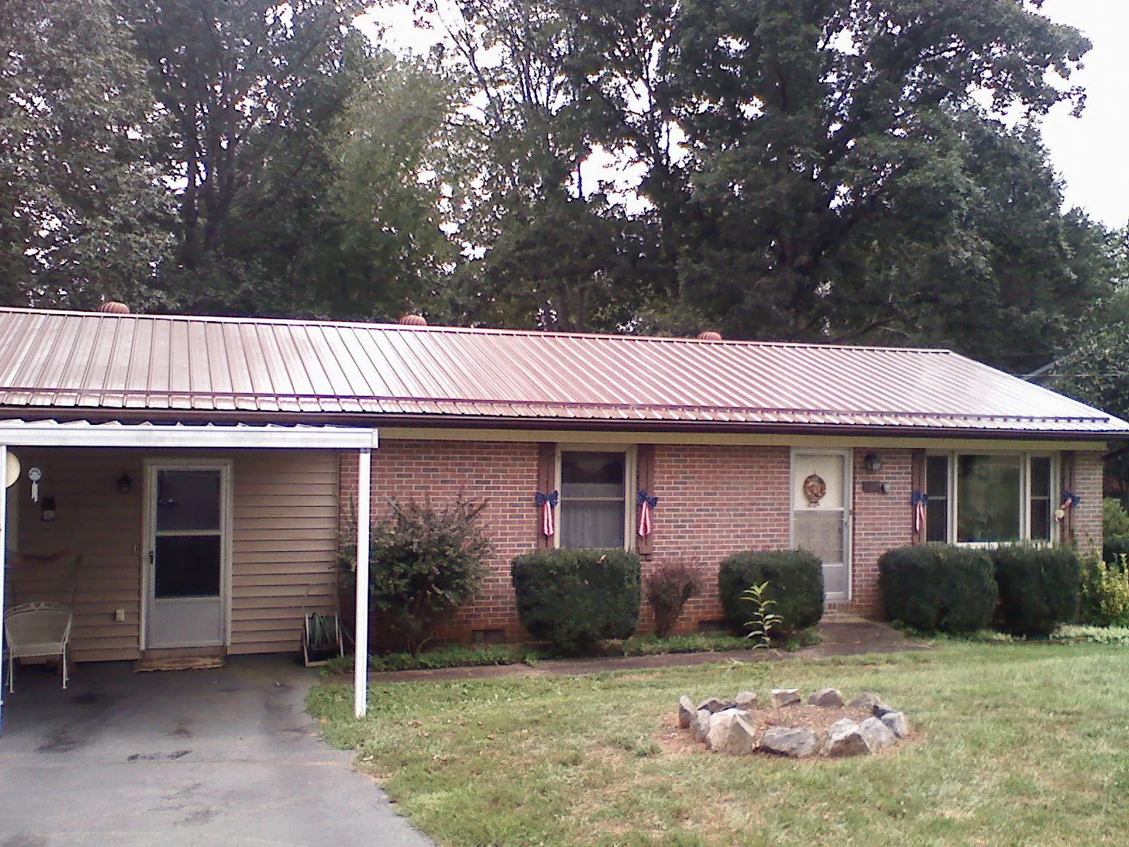 Bronze metal roof and carport on a brick ranch home — Roof Repair work by our crew in Garden City